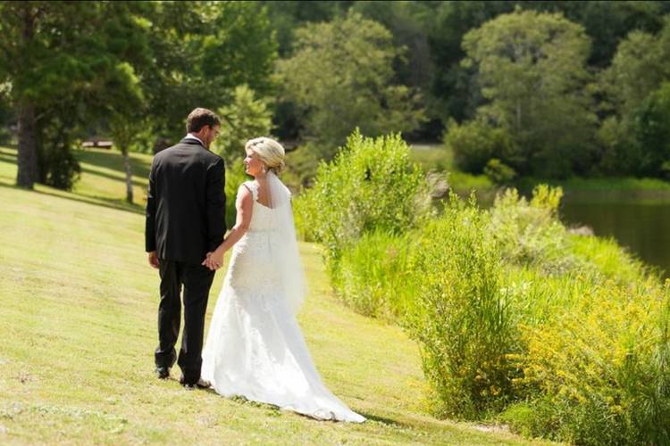 03 bride and groom walking beside lake holding hands